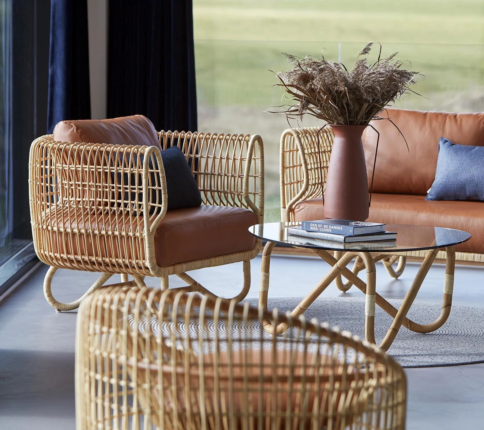 A Cane-line Nest lounge chair in Cane-line Weave on an outdoor terrace