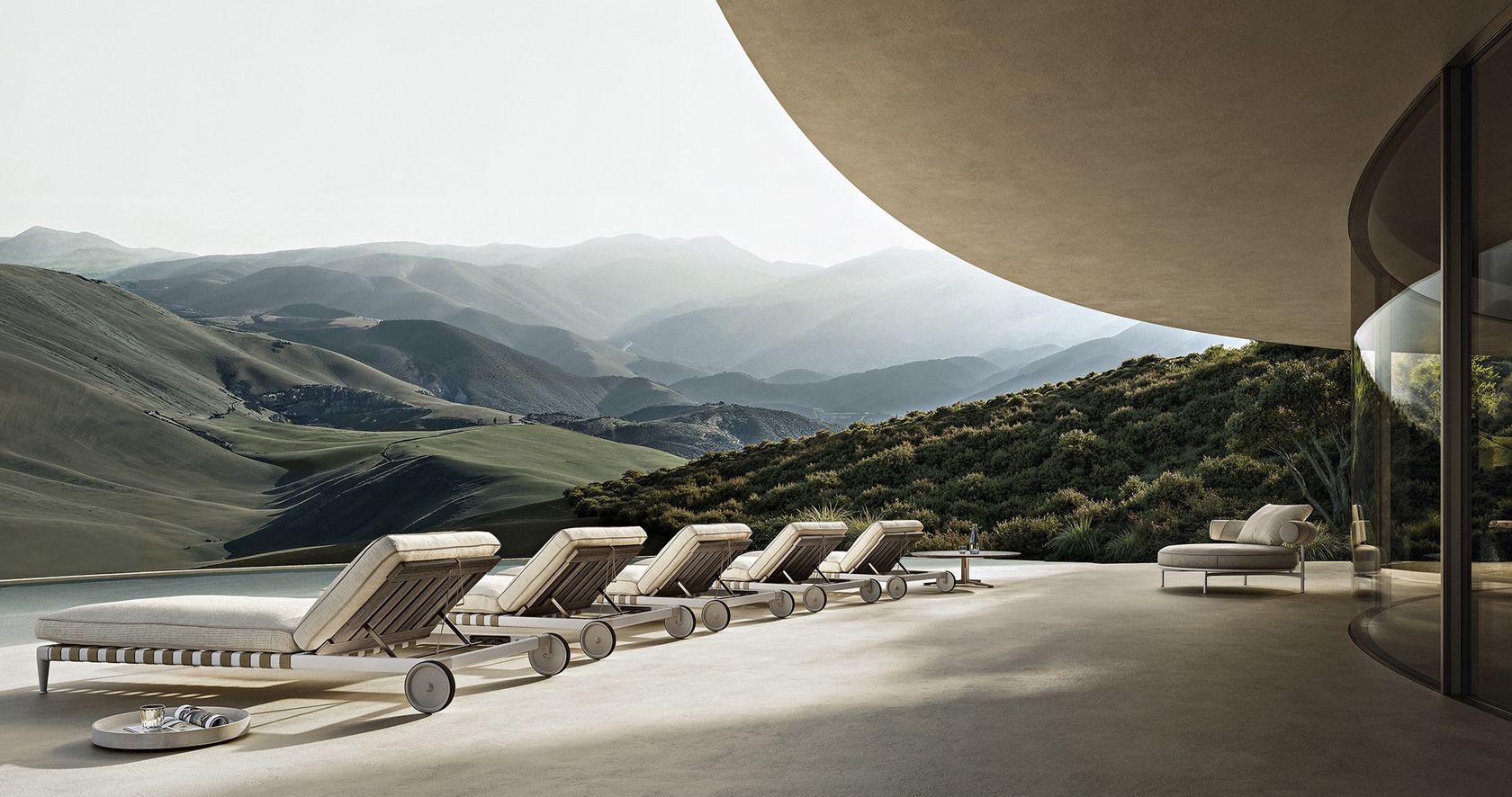 Flexform Atlante outdoor daybeds lined along a stone terrace above a mountain valley, no people