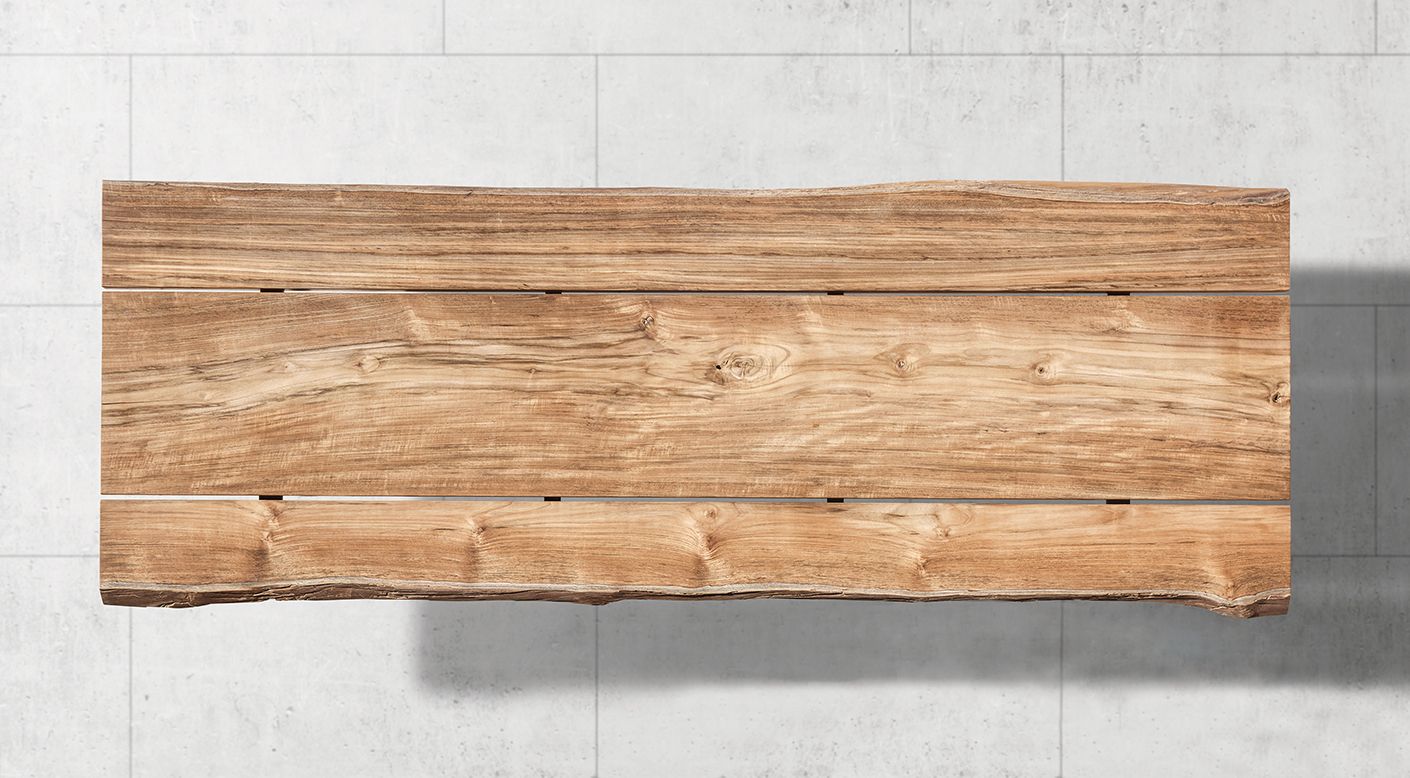 Gloster Raw outdoor dining table in plantation teak showing natural grain and growth rings